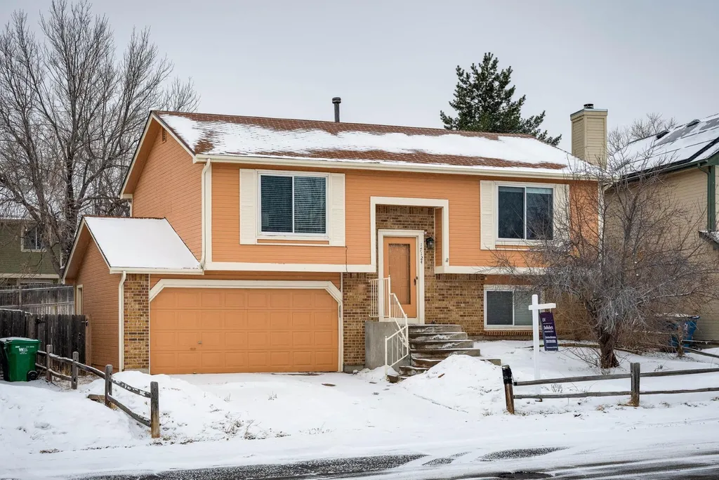 Snow-covered suburban house with a “For Sale” sign, illustrating the choice between selling to cash buyers or hiring a realtor.