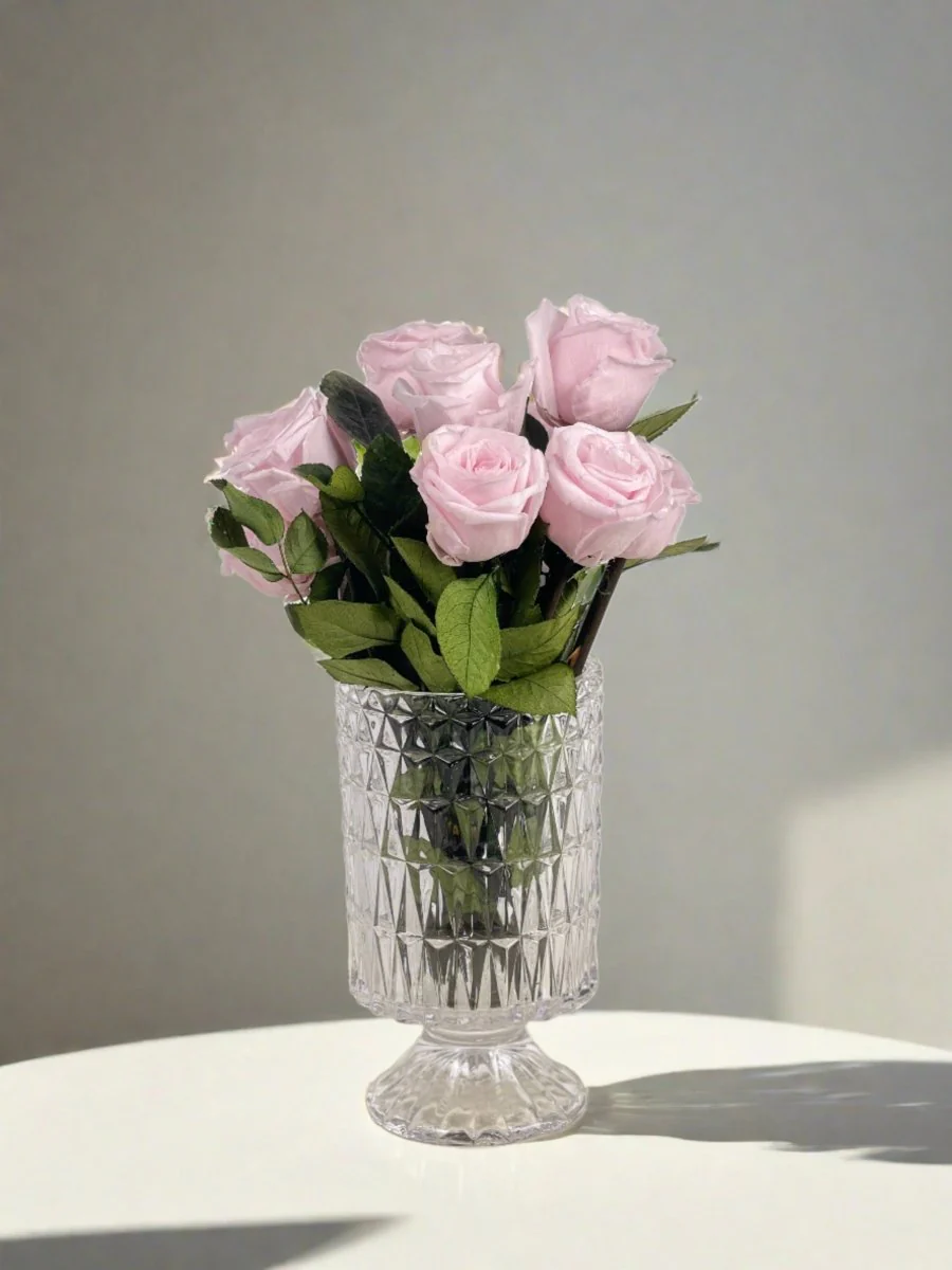 Elegant pink preserved roses in a textured glass vase, perfect for stylish home decoration.