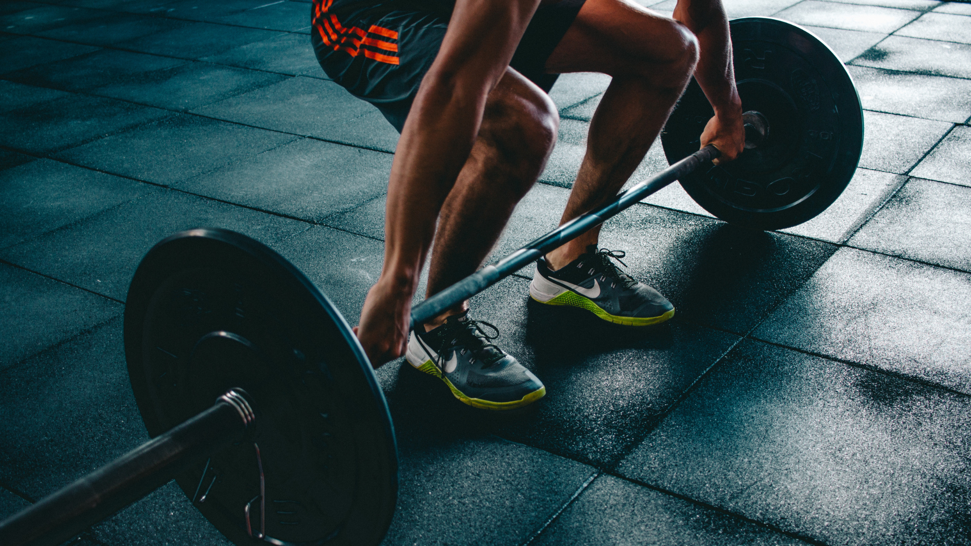 Person performing a deadlift with a barbell at the gym.