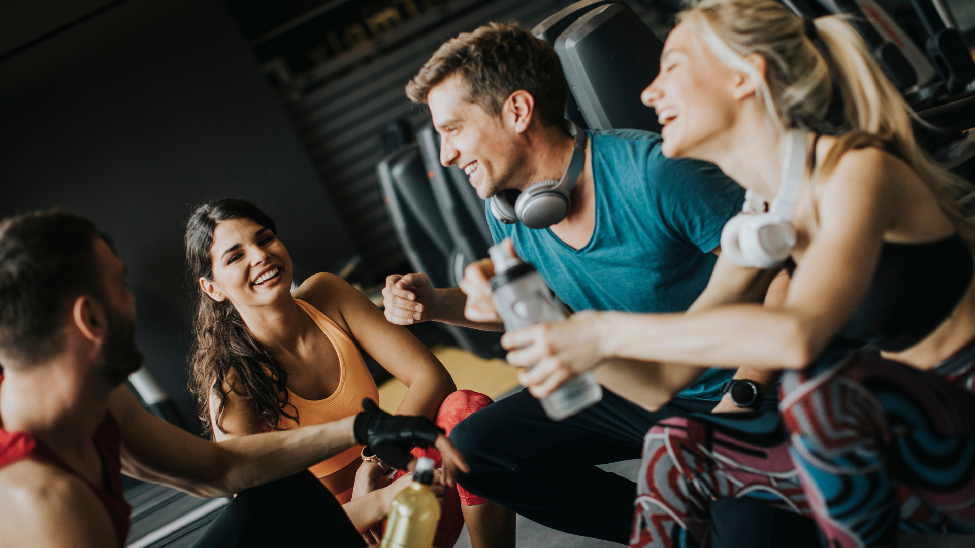 Group of friends laughing and resting at the gym.