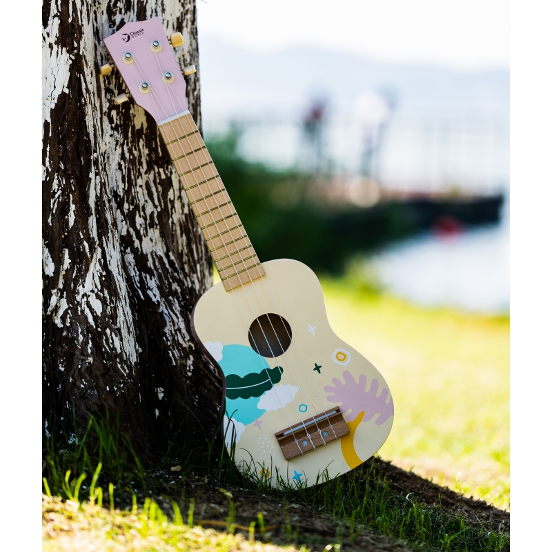 Kolorowe dziecięce ukulele z wesołymi wzorami opiera się o drzewo, symbolizując edukacyjne i pełne radości elementy charakterystyczne dla zabawek marki Classic World.